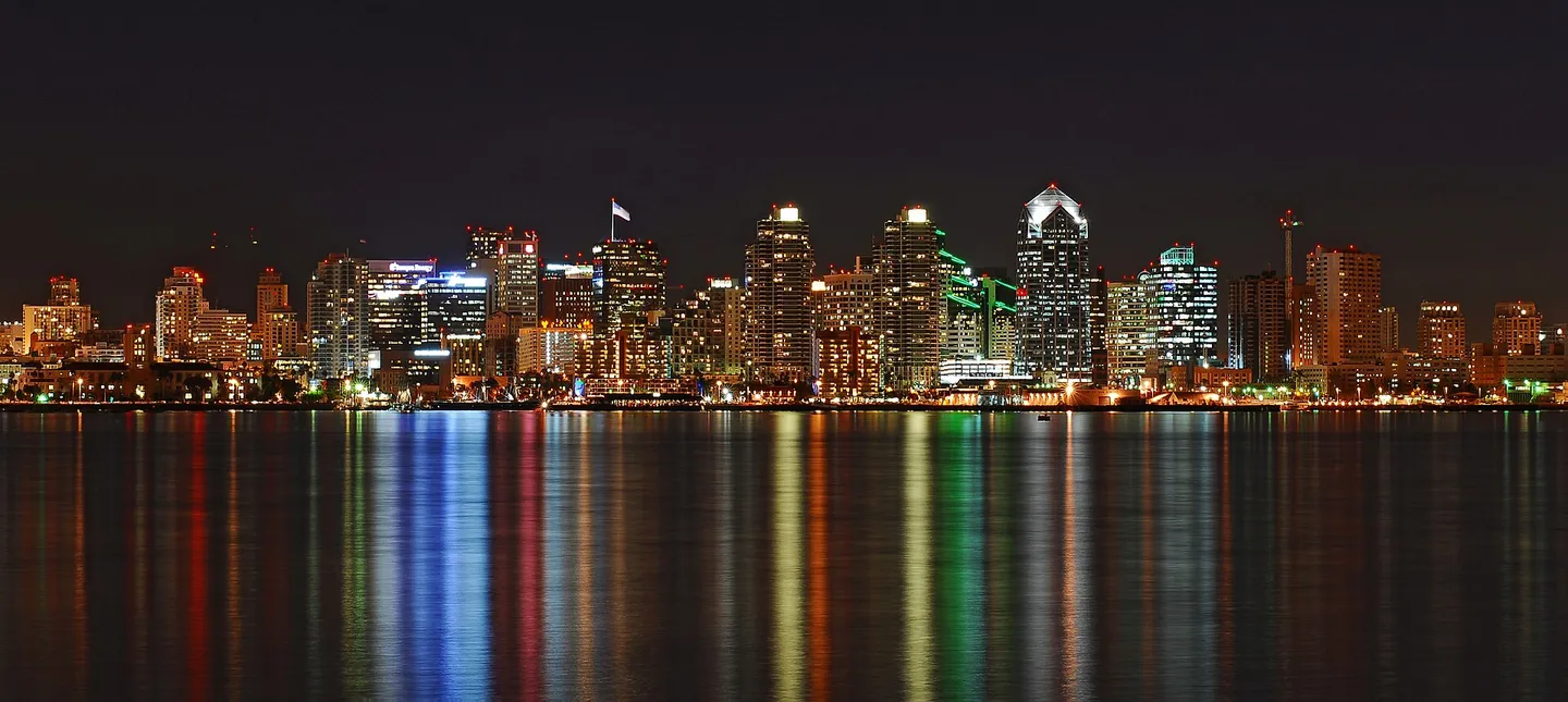 Downtown San Diego skyline reflected across the waterfront at night